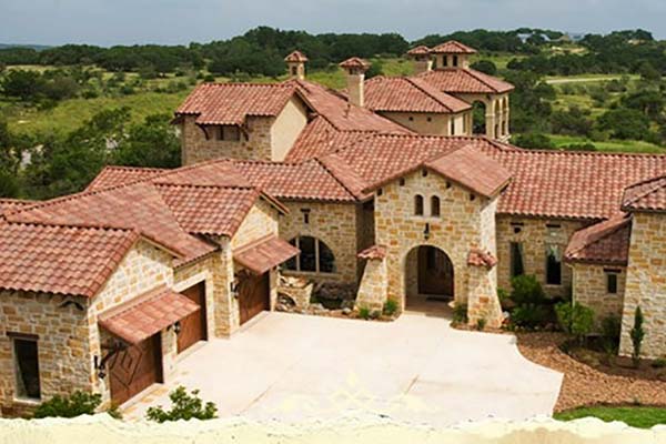 Front view of a large, high-end home with a rust colored tile roof