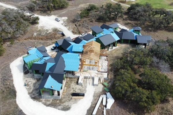 Top view of a group of houses under new construction getting a new roof and shingles installed